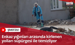 Enkaz yığınları arasında kirlenen yolları süpürgesi ile temizliyor